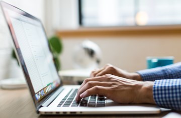 Close up of a laptop with person typing